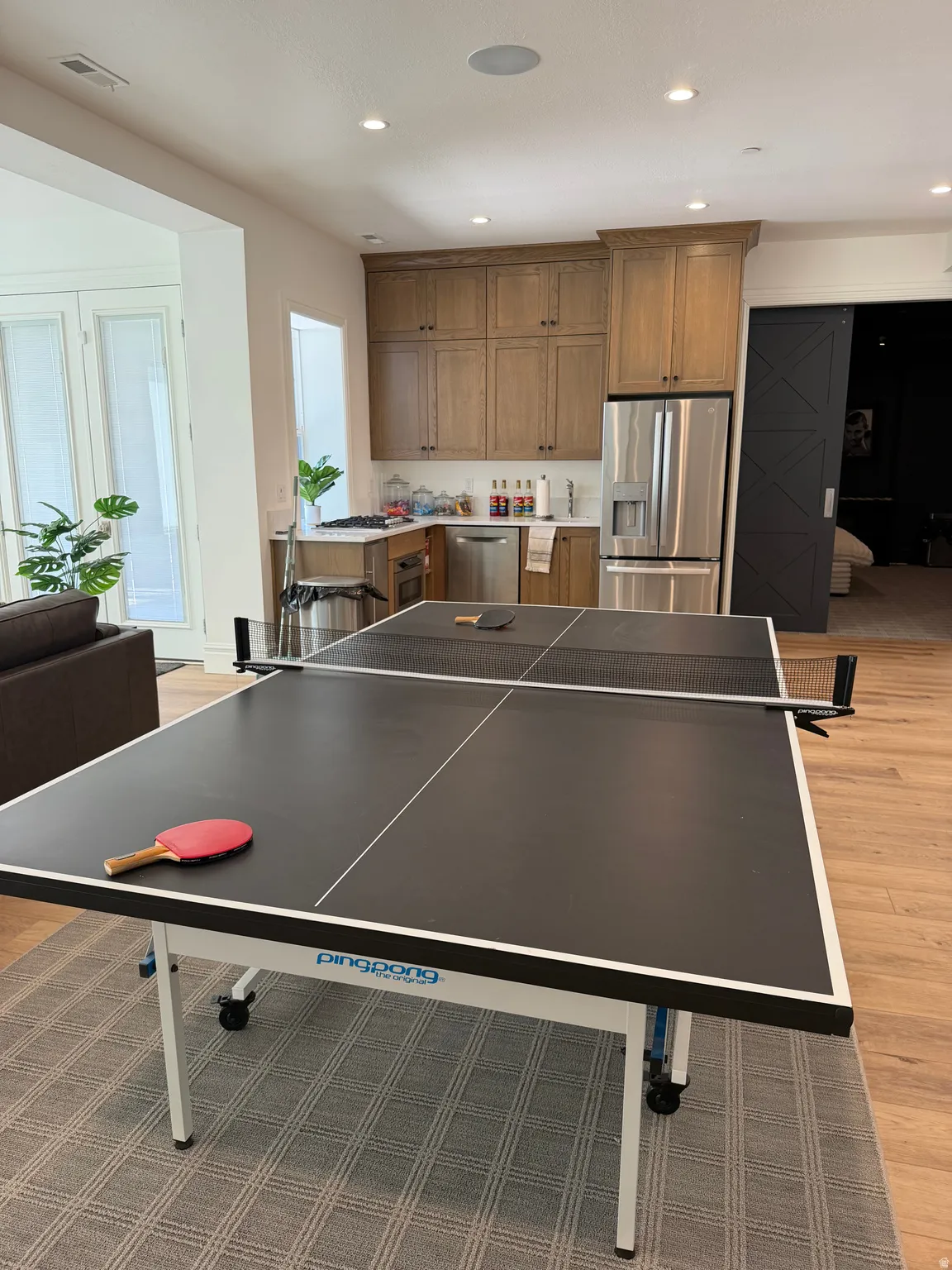 Open-concept living area with wood-finish flooring, recessed lighting, and a neutral color palette