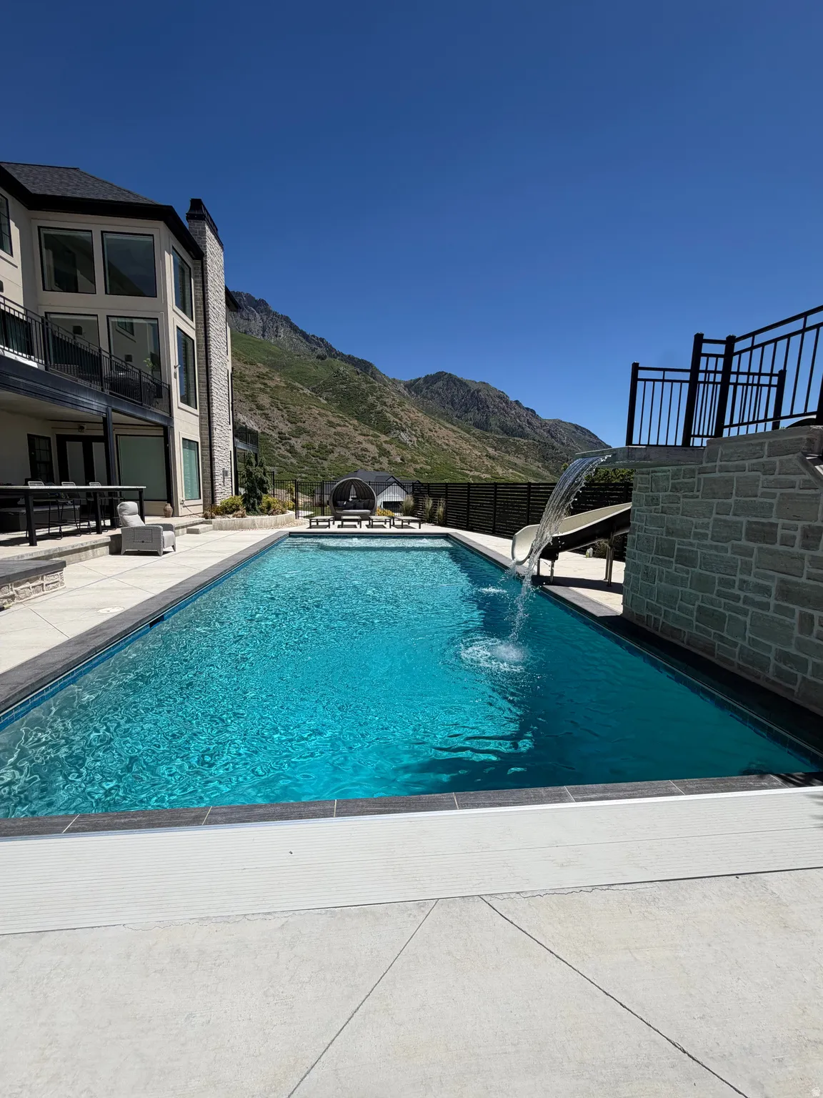 Rectangular inground pool with integrated spa and waterfall feature