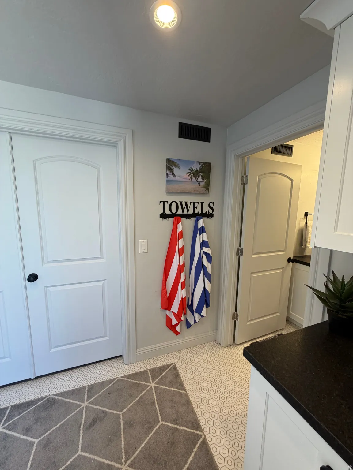 Recessed ceiling lighting illuminates a white honeycomb tile floor