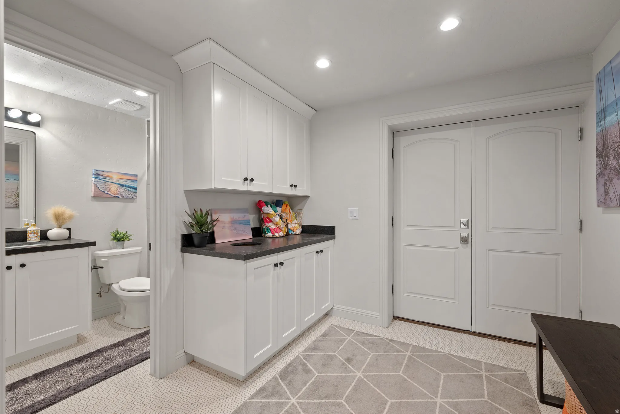 White cabinetry with dark countertops, recessed lighting, and double-paneled doors
