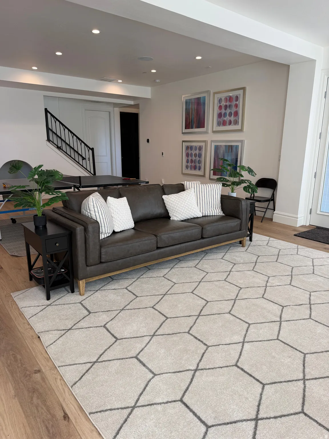 Spacious room featuring recessed lighting, light wood-finish flooring, and a contemporary staircase with black railings