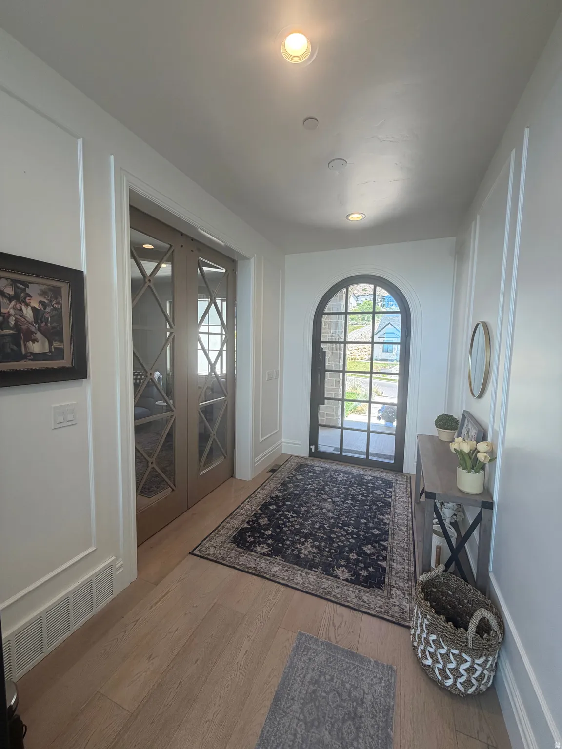 Entryway featuring light wood-finish flooring, recessed lighting, and white wainscoting