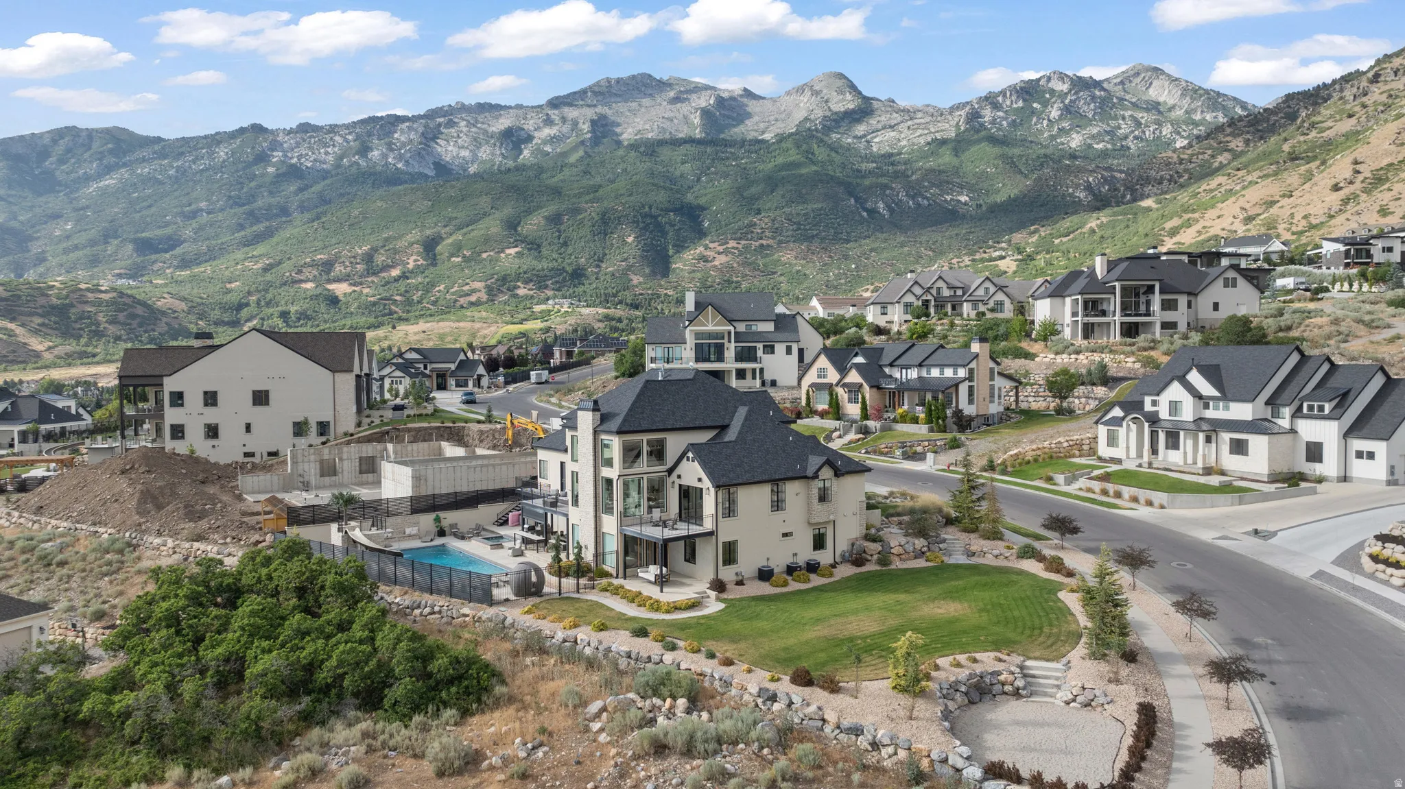 Hillside property with a private pool, an expansive lawn, and balconies offering mountain scenery