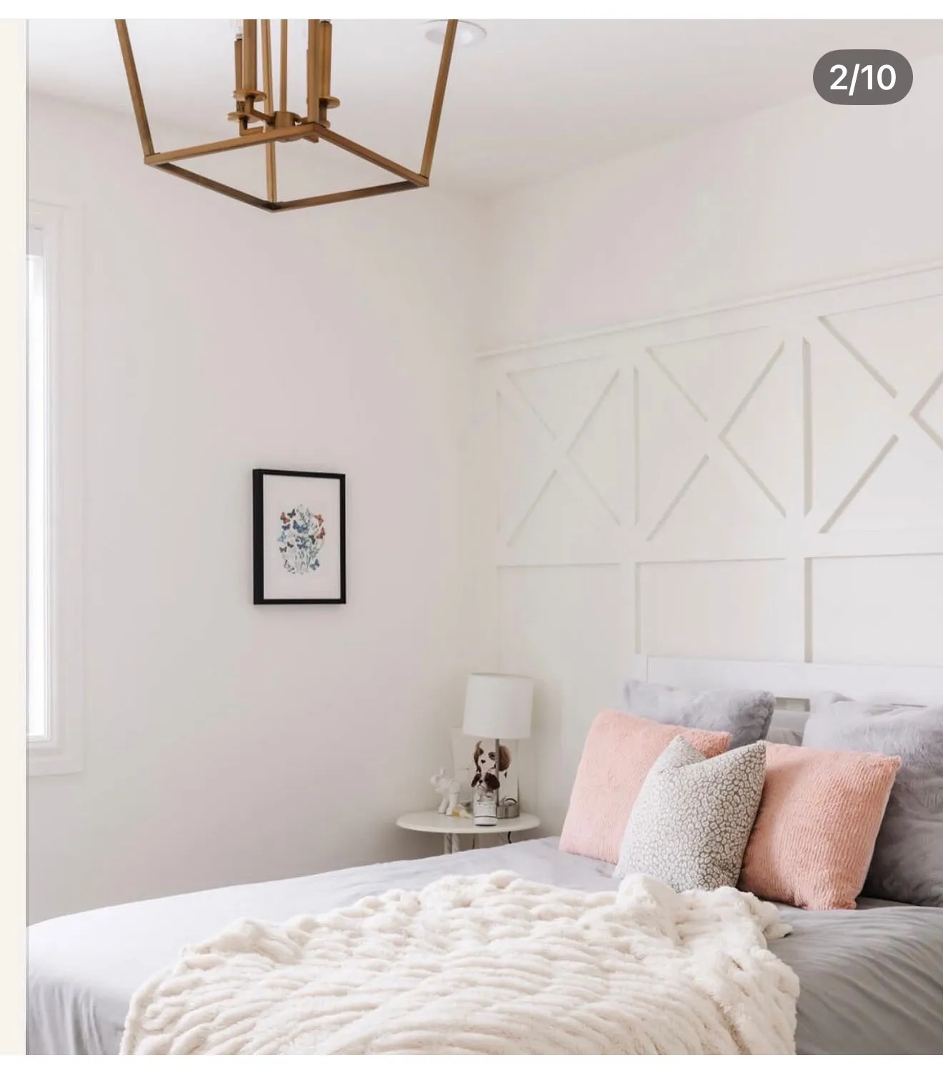 White bedroom featuring a decorative accent wall with geometric paneling