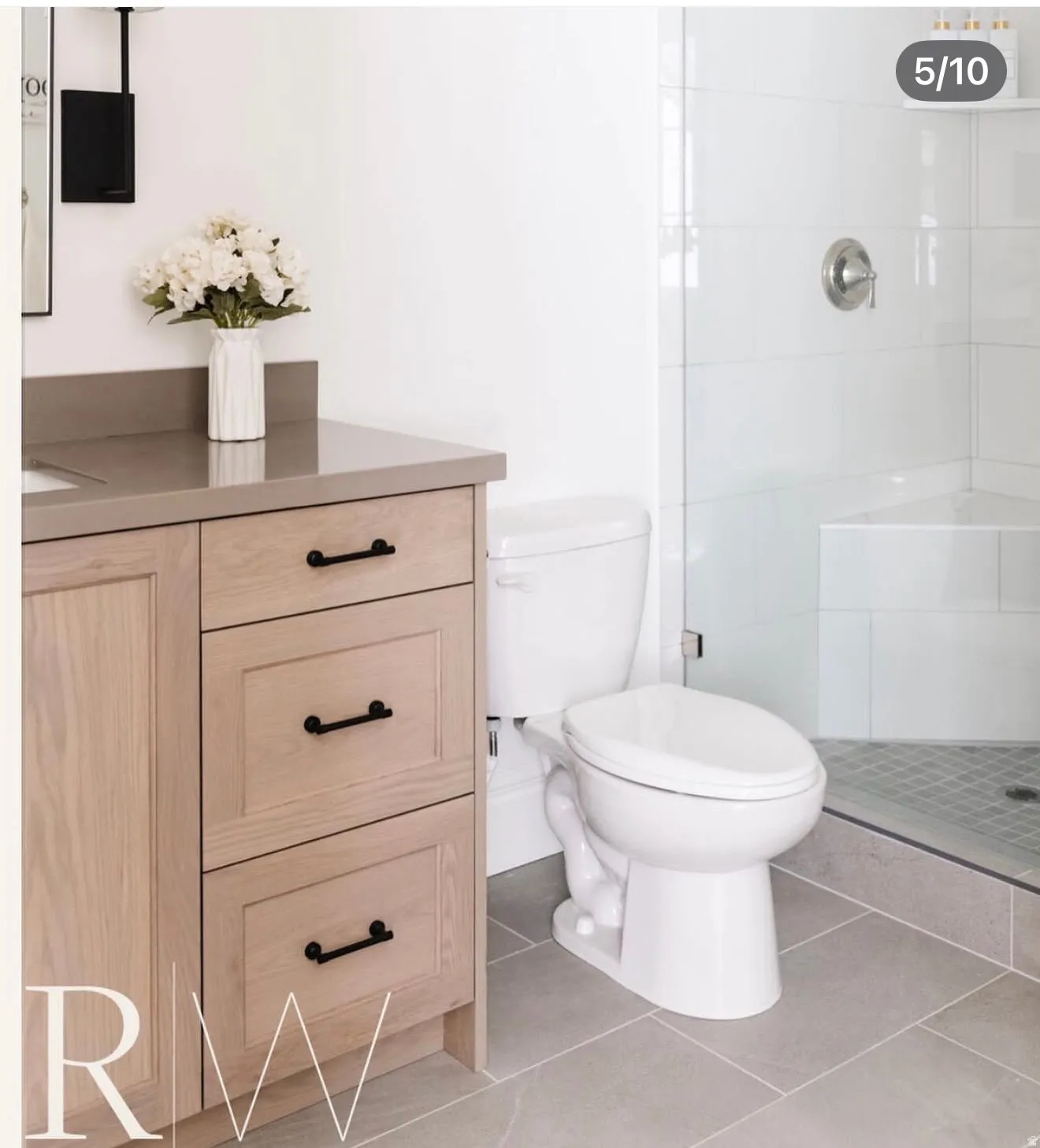 Neutral-toned vanity with a solid surface countertop and matte black hardware