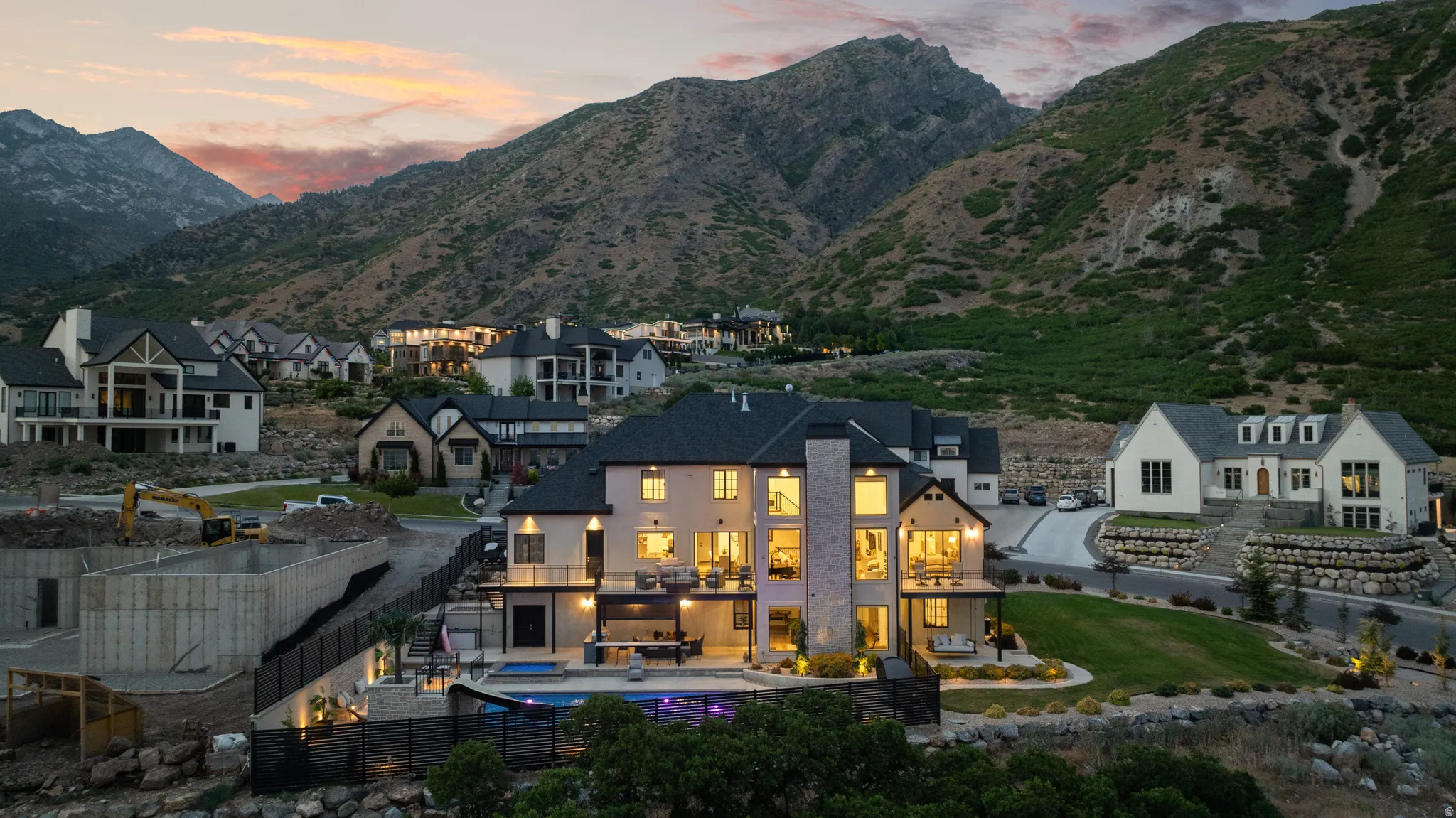 Stone and stucco exterior residence featuring multiple balconies and expansive windows