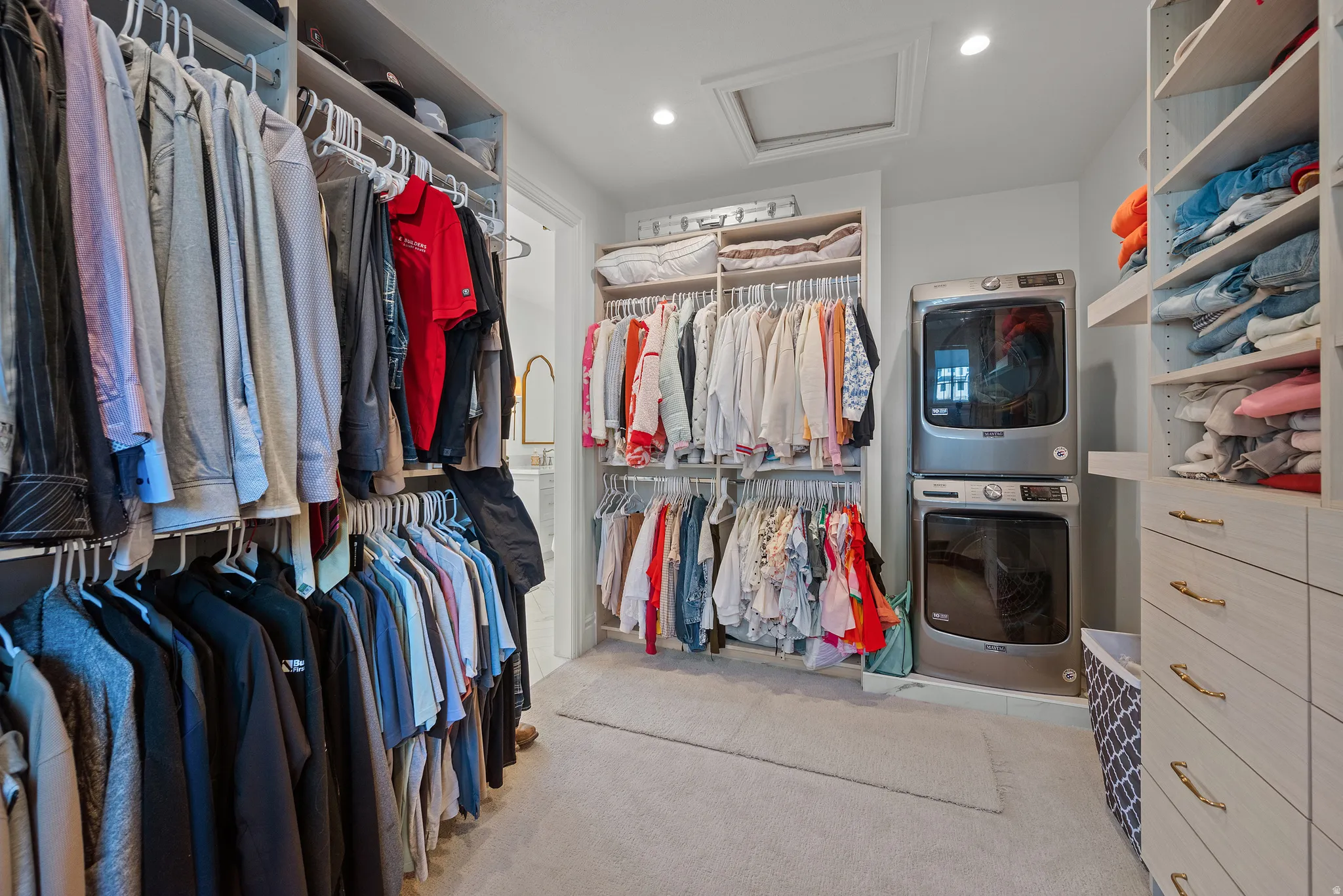 Built-in closet system featuring multiple hanging rods, shelving, and drawer storage