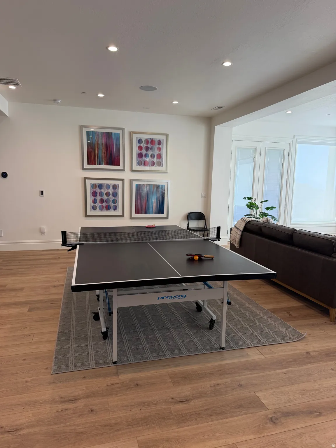 Spacious room featuring wood-finish flooring, recessed lighting, and large windows