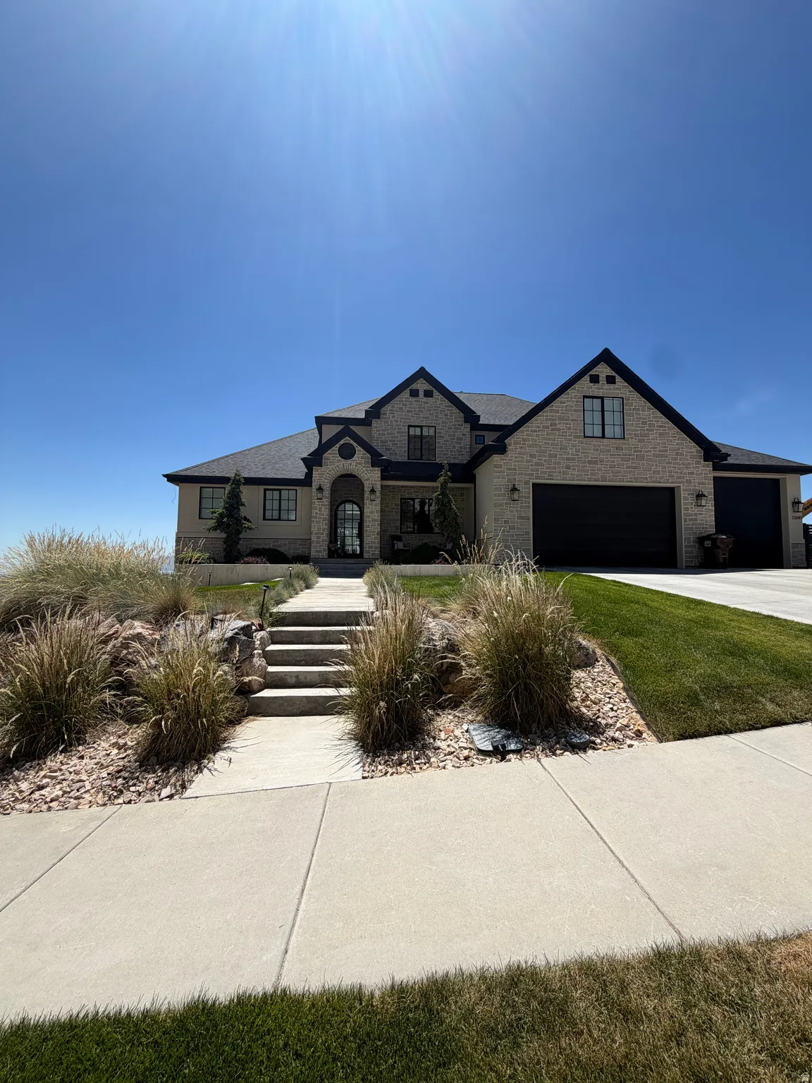 Stately stone residence featuring a multi-gabled roofline and dark trim accents