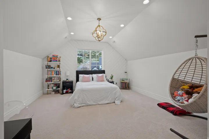 Spacious room with a vaulted ceiling, recessed lighting, and an ornate ceiling fixture