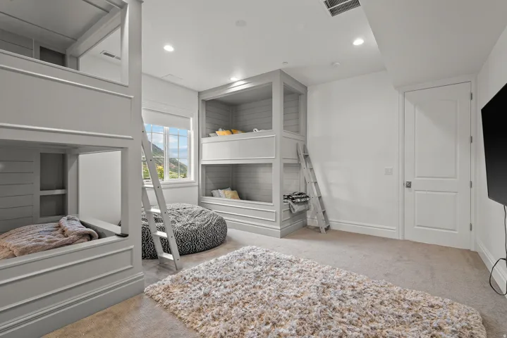 Custom built-in bunk beds with paneled construction and integrated ladders