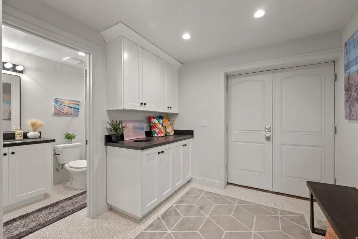 White cabinetry with dark countertops, recessed lighting, and double-paneled doors