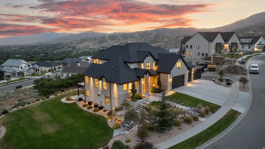 Modern residence featuring stone and stucco exterior, multiple gables, a three-car garage, and a concrete driveway