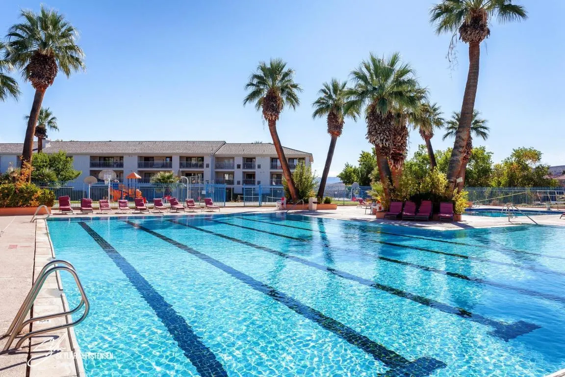 Community swimming pool with lap lanes, surrounded by a concrete deck