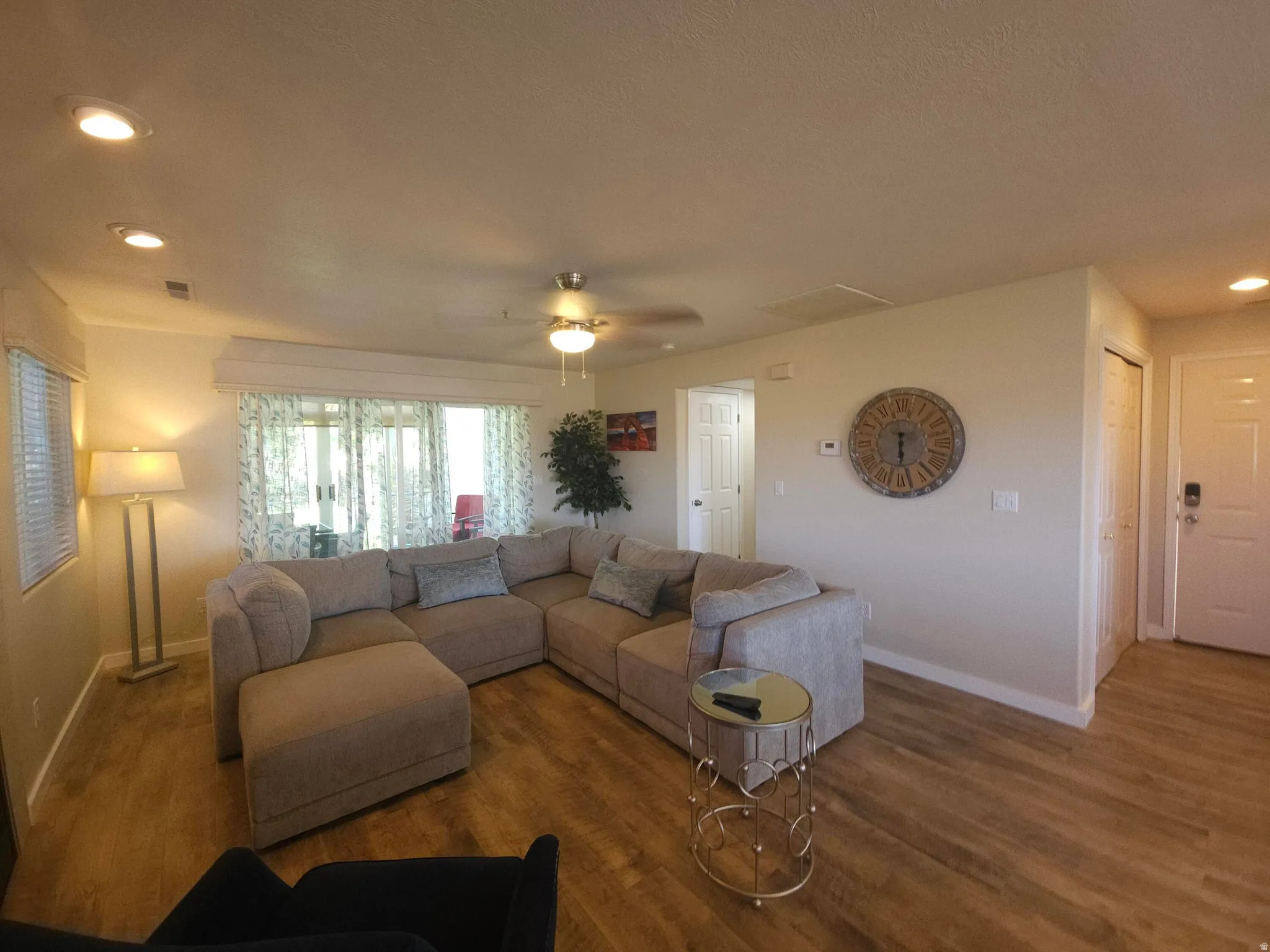 Open-concept living space featuring wood-finish flooring, recessed lighting, and a ceiling fan