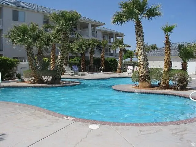 Freeform swimming pool with a concrete deck and red brick coping
