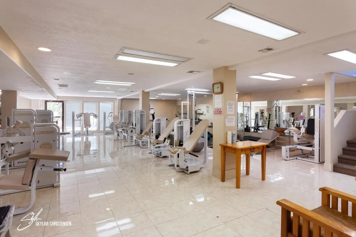 Spacious fitness center featuring a variety of exercise equipment, large format tile flooring, recessed lighting, and expansive windows