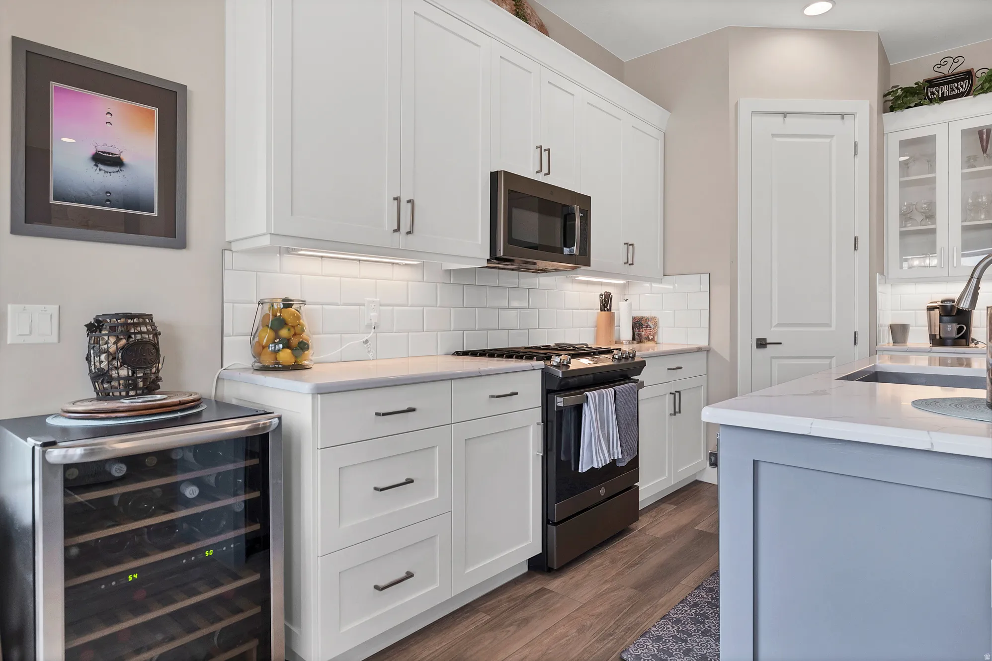 Contemporary kitchen featuring white shaker cabinetry and coordinating subway tile backsplash