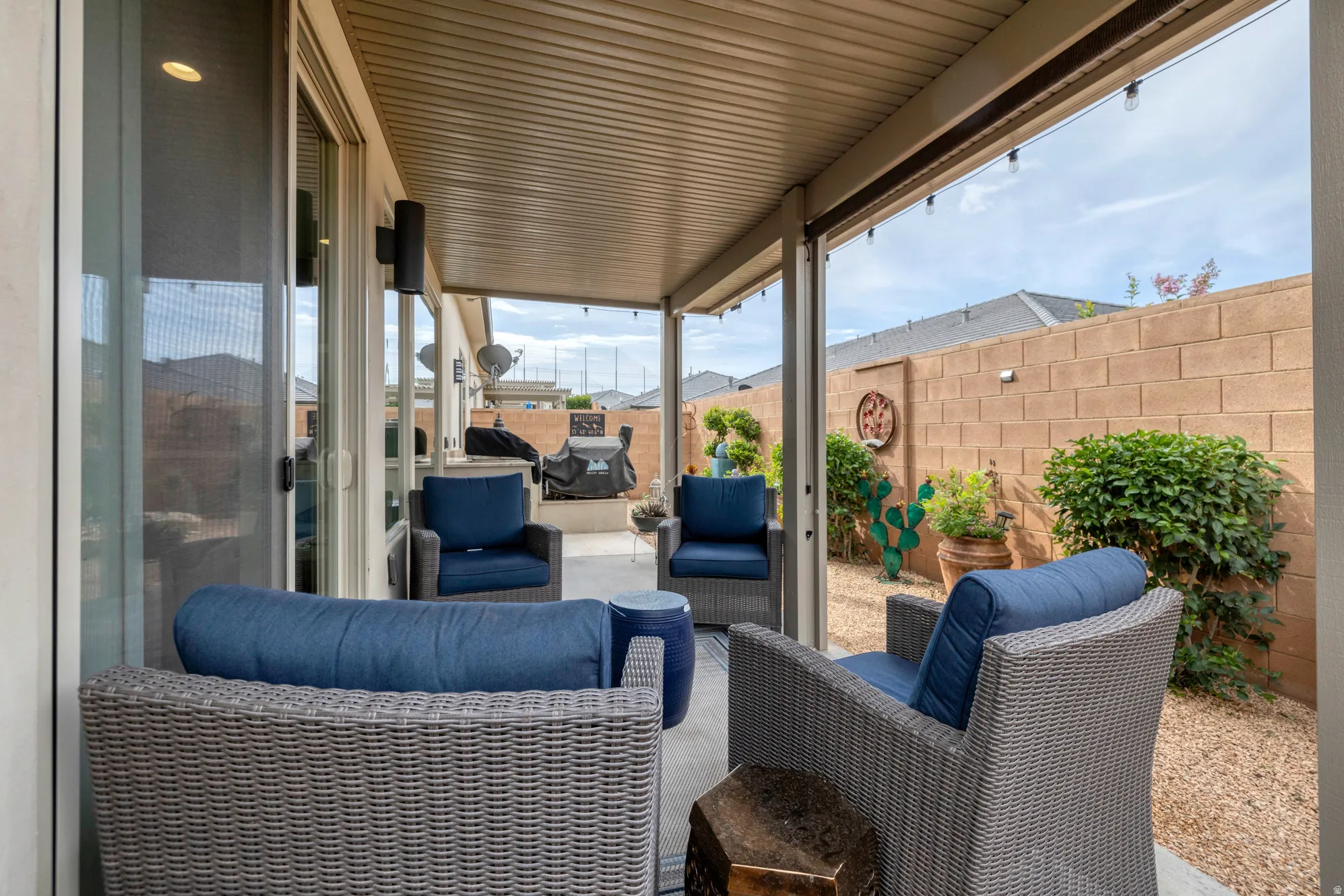 Covered patio with recessed lighting, exposed aggregate concrete flooring, and string lights
