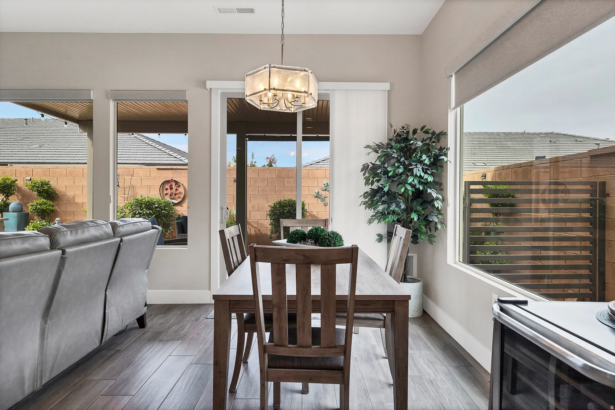Dining area featuring wood-finish flooring, a contemporary chandelier, and a sliding glass door providing access to the outdoors