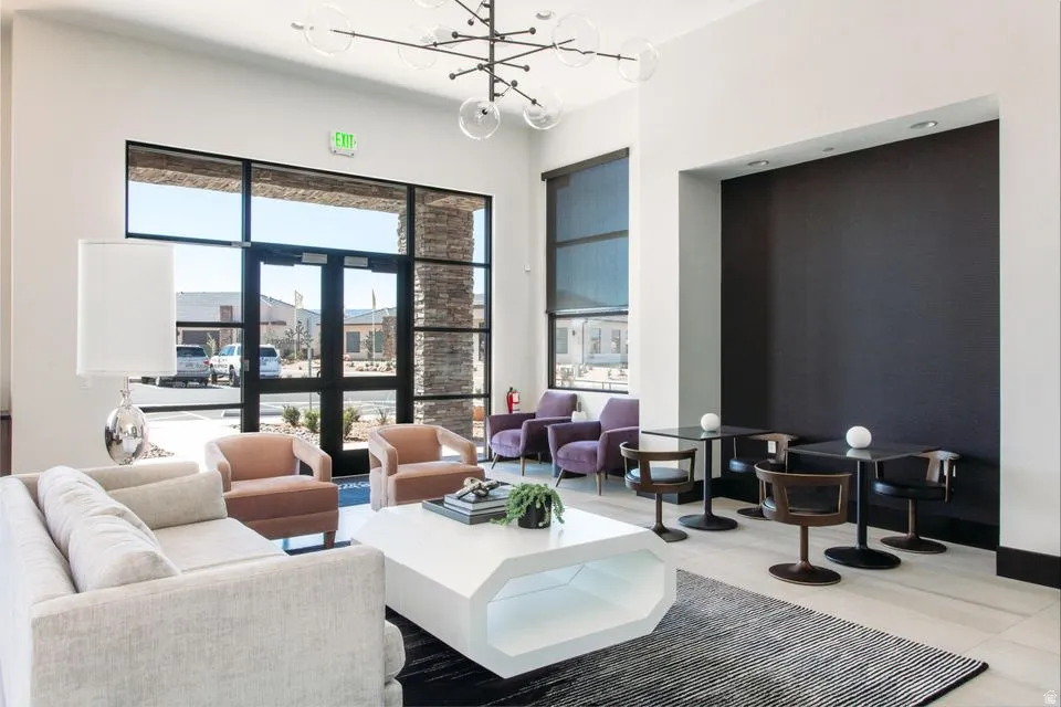 Spacious common area featuring high ceilings, a modern chandelier, and large windows