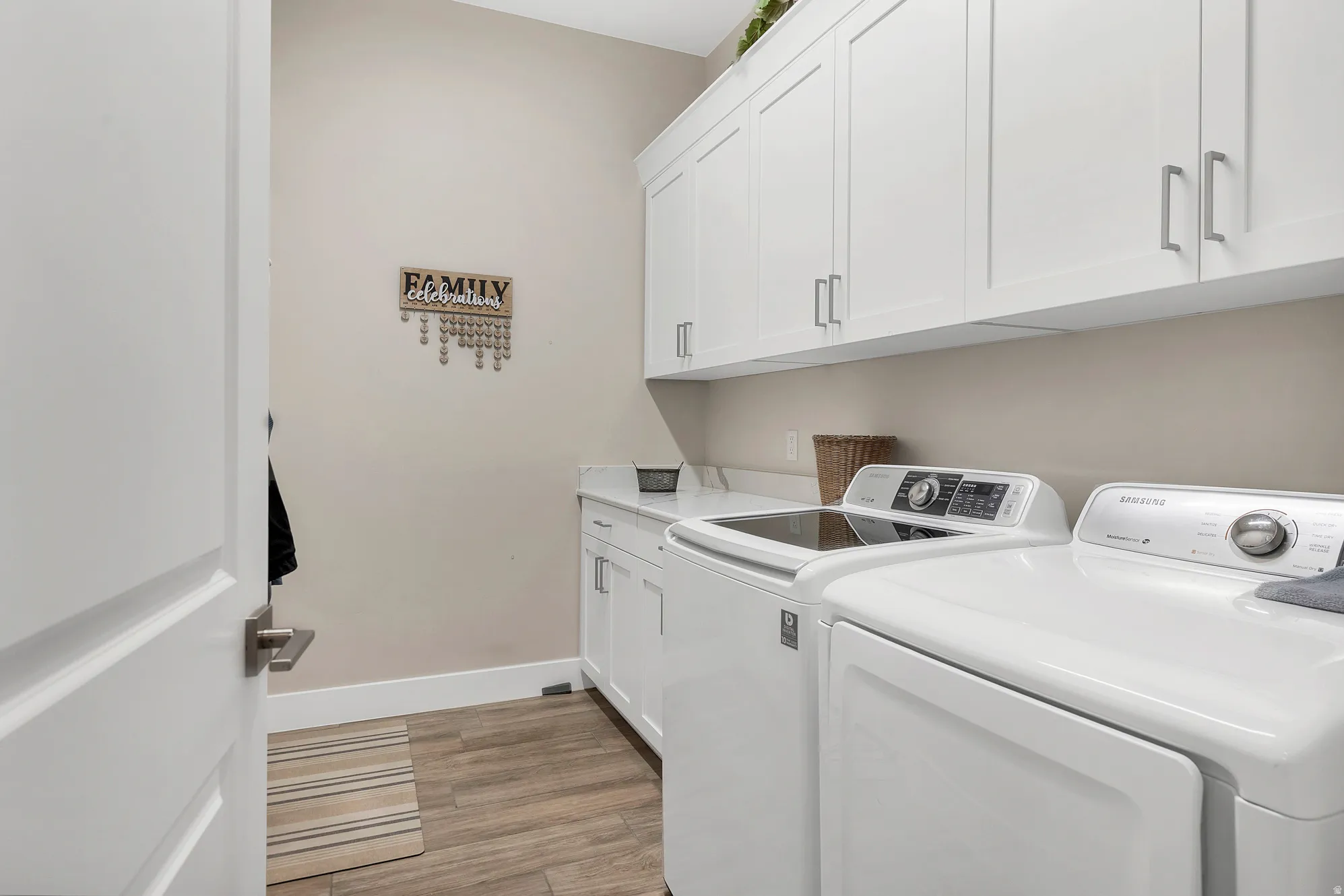 Dedicated laundry area featuring wood-finish flooring