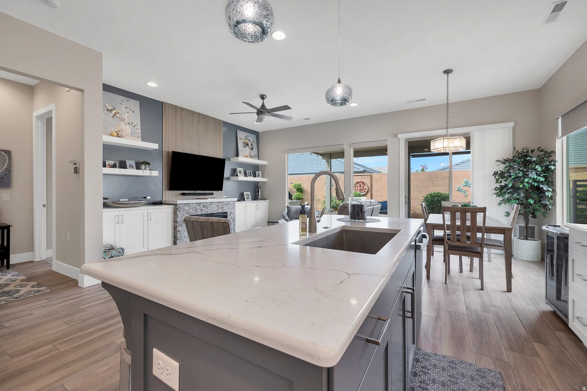 Kitchen island featuring a substantial countertop with an undermount sink and a gooseneck faucet