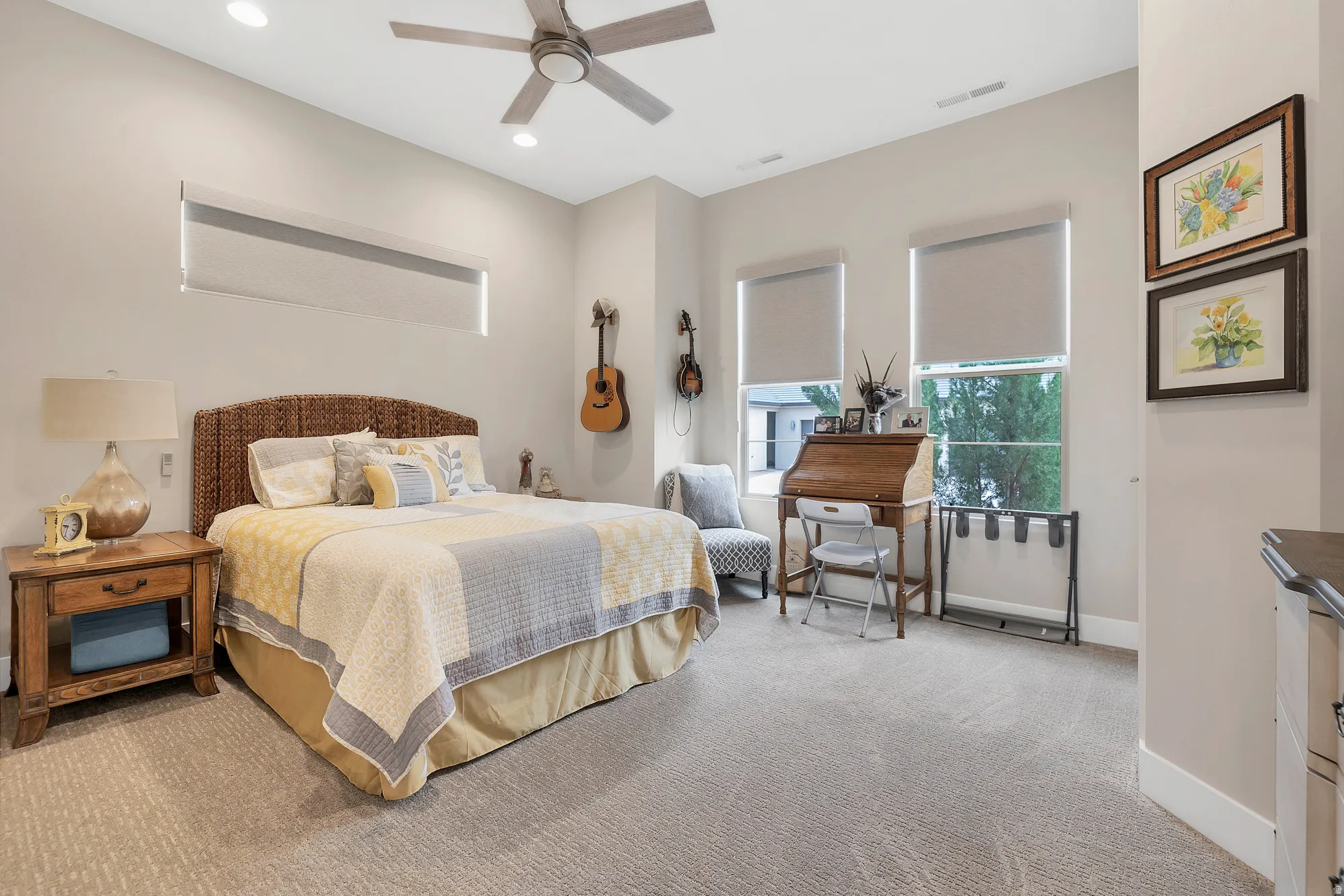 Spacious bedroom featuring neutral carpeting, a ceiling fan with integrated lighting, recessed lighting, and multiple windows with roller shades