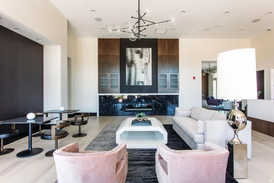 Spacious common area featuring a modern fireplace with black stone surround, dark wood cabinetry, and recessed lighting