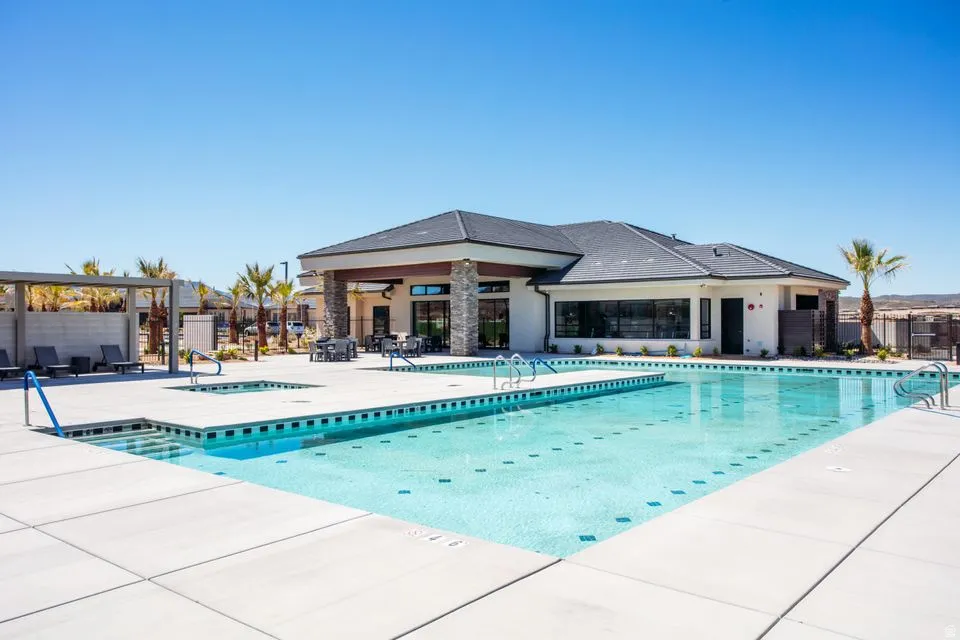 Outdoor swimming pool with integrated spa, surrounded by a concrete deck