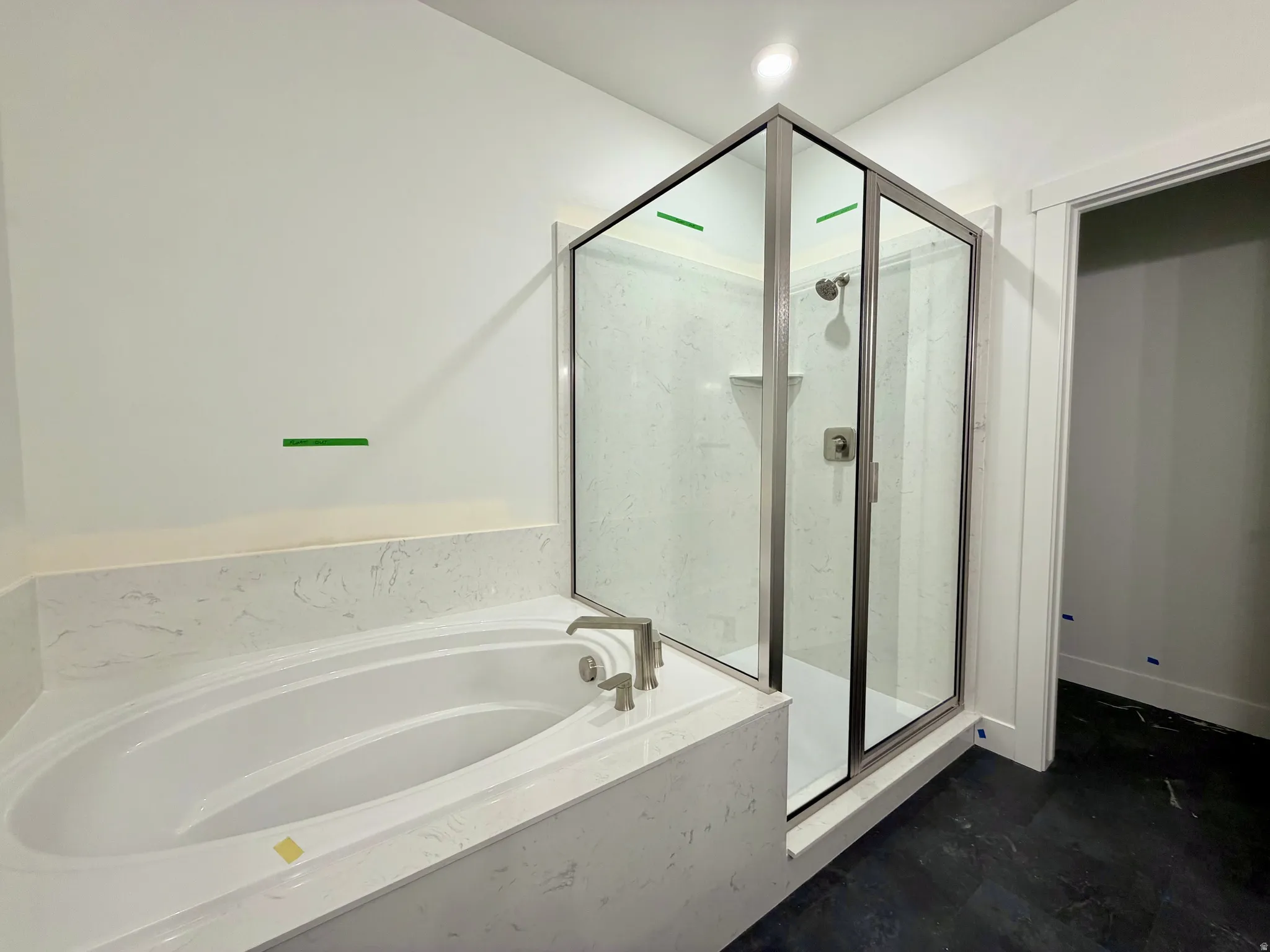 Built-in soaking tub with brushed nickel fixtures and a surrounding stone-finish deck