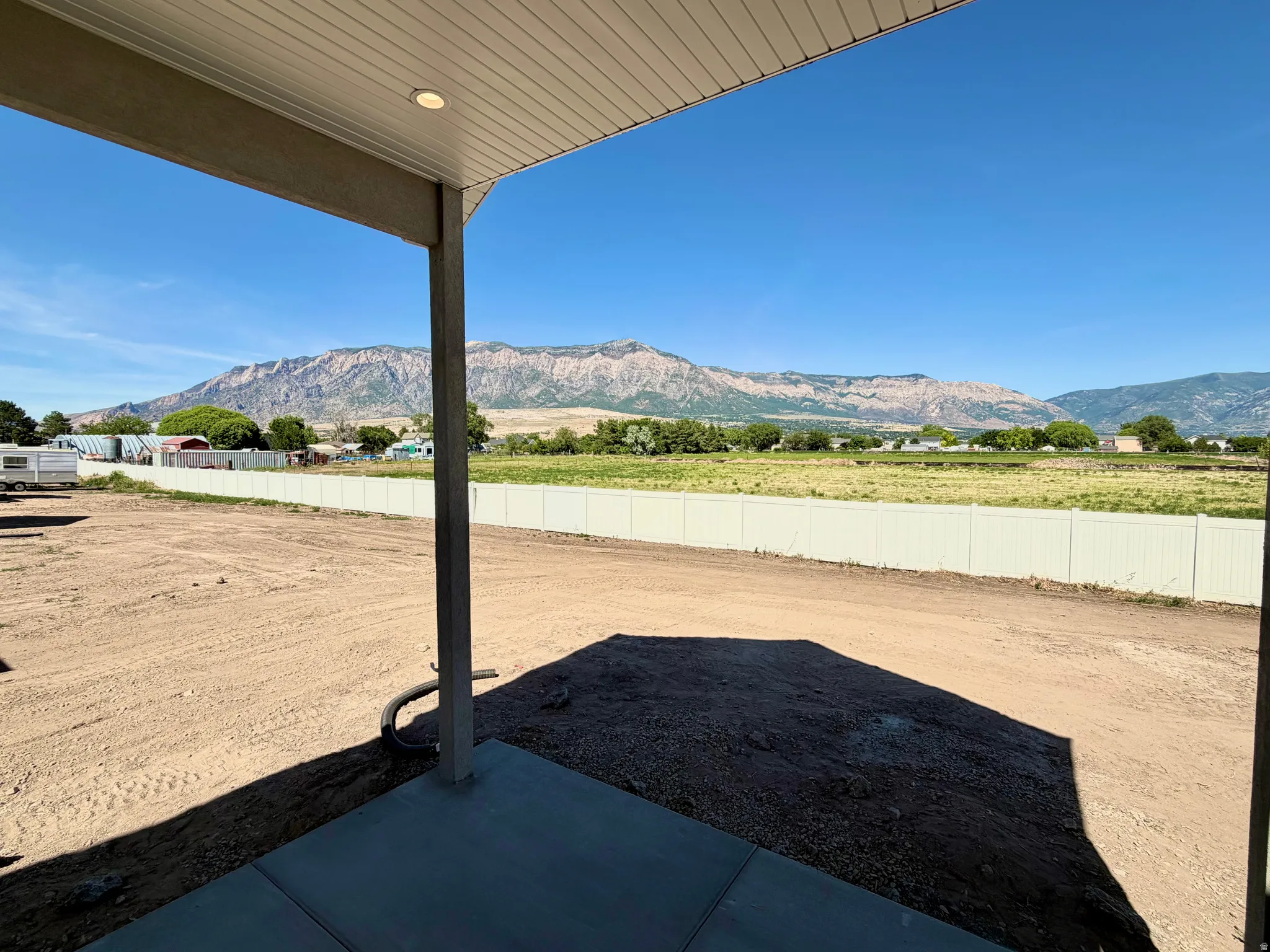 Covered patio with recessed lighting, concrete flooring, and distant mountain scenery