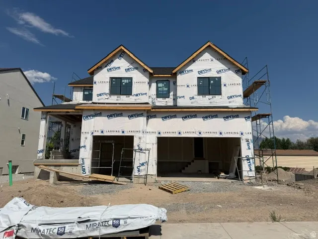 Two-story residential structure featuring multiple gables and a dark shingle roof