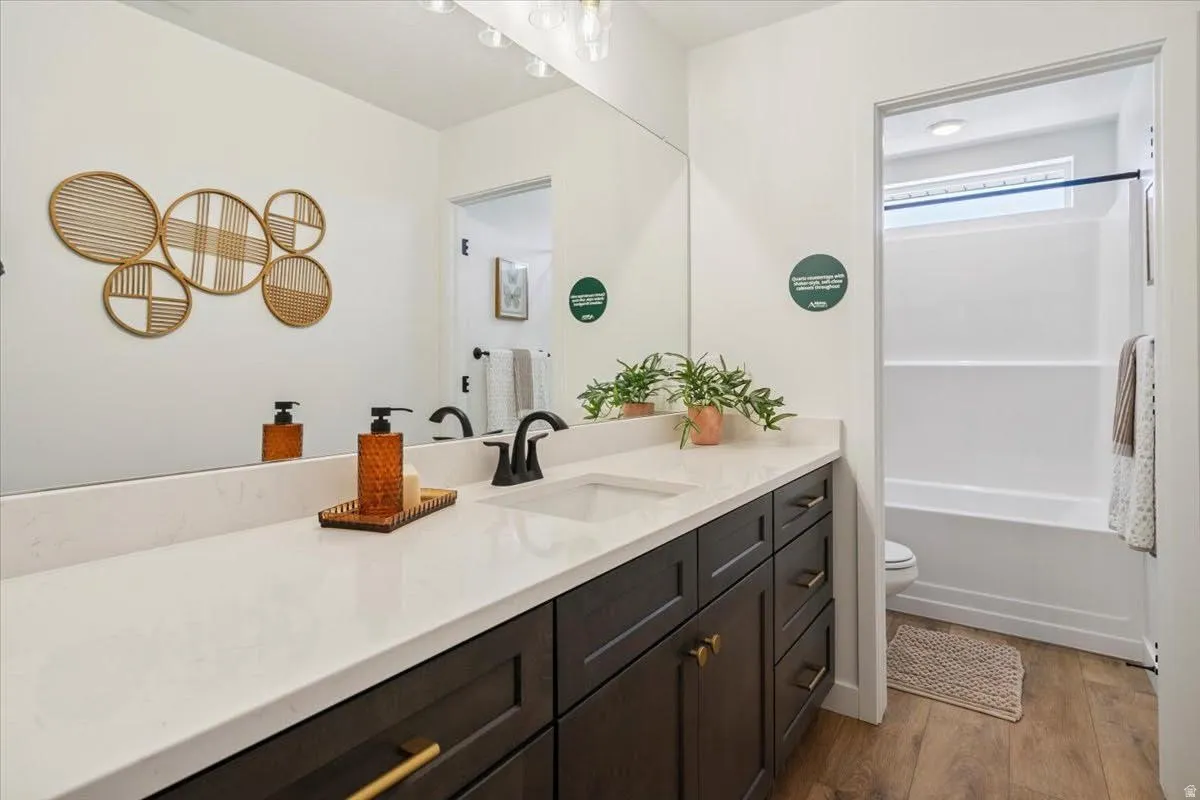 Bathroom featuring an expansive vanity with dark wood-finish cabinetry and gold-tone hardware