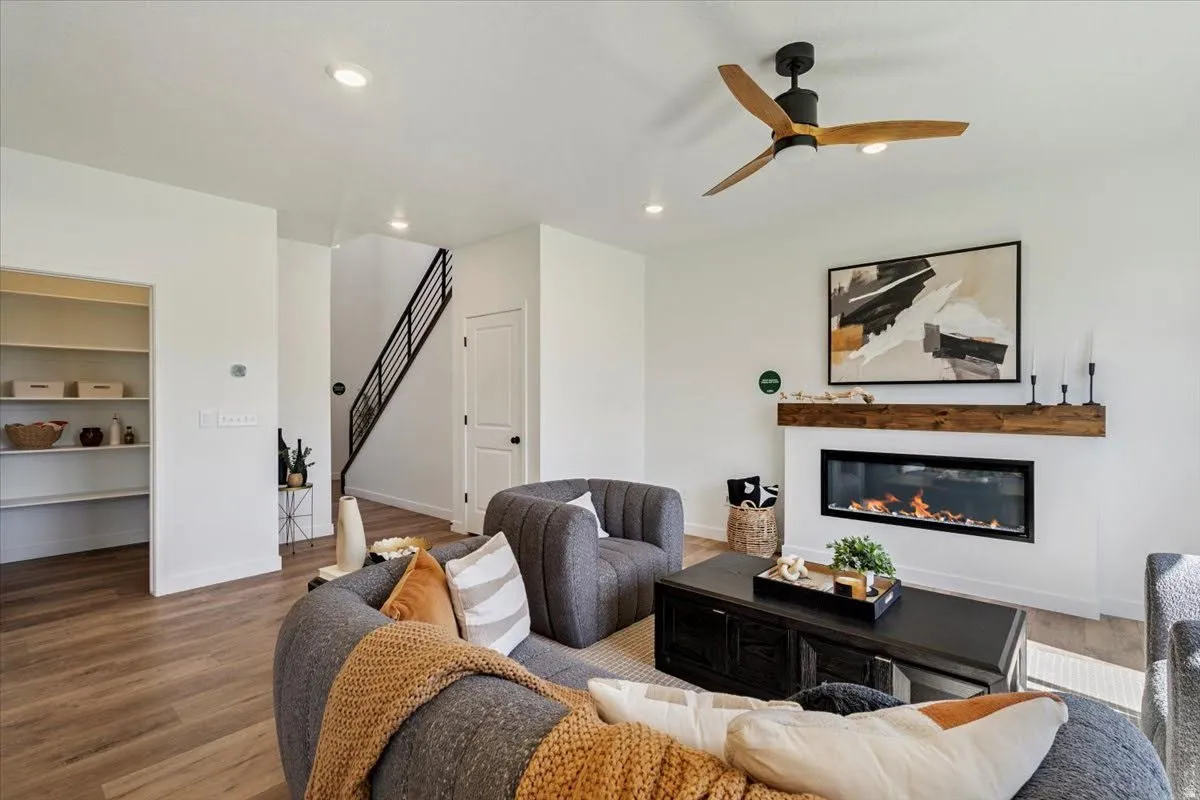 Living space featuring wood-finish flooring, a contemporary linear fireplace with a wood mantle, and recessed ceiling lighting