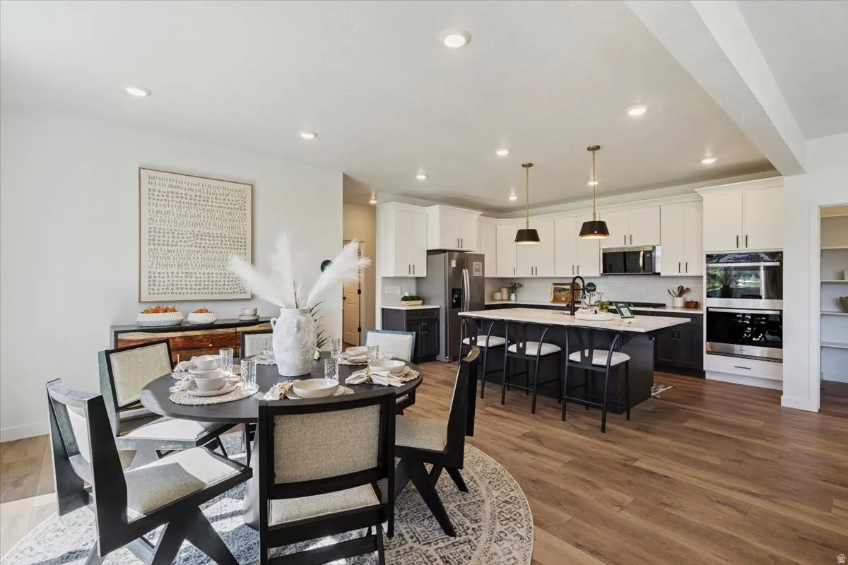 Open-concept living space featuring wood-finish flooring, recessed lighting, and a white ceiling