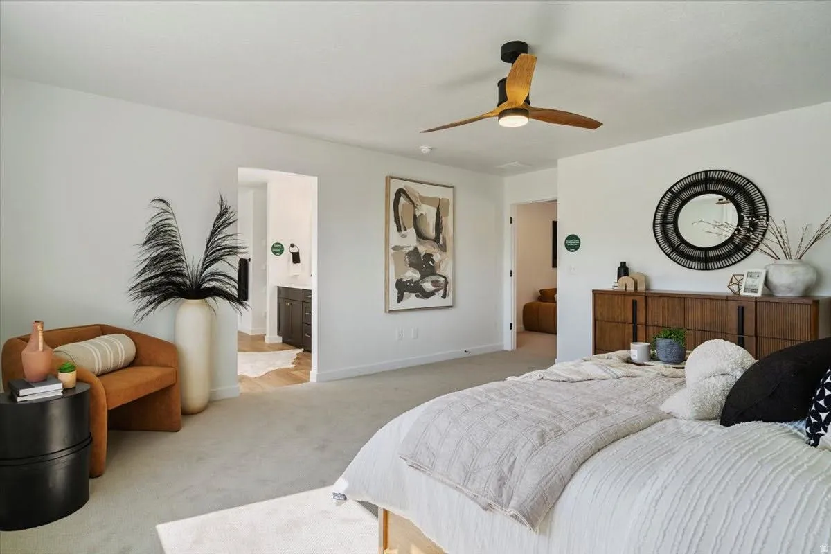 Light-colored carpeting with a wood-finish ceiling fan and recessed lighting