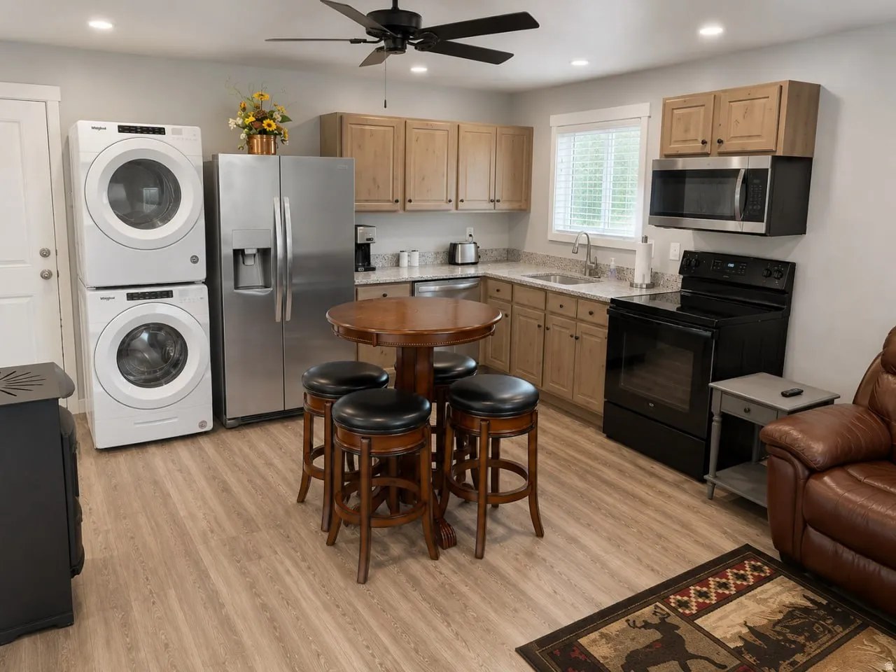 Kitchenette featuring wood-finish flooring and light-toned cabinetry