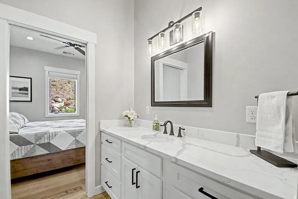 Bathroom vanity featuring a light-toned countertop, dual rectangular sinks, and dark-toned fixtures