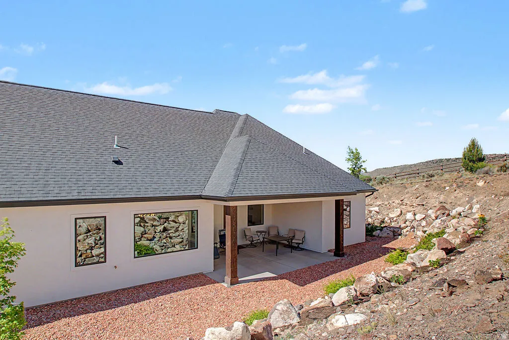 Exterior featuring a covered patio with columns, a stucco facade, and a dark shingle roof