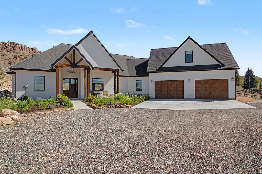 Contemporary stucco residence featuring a prominent gabled entry with timber framing