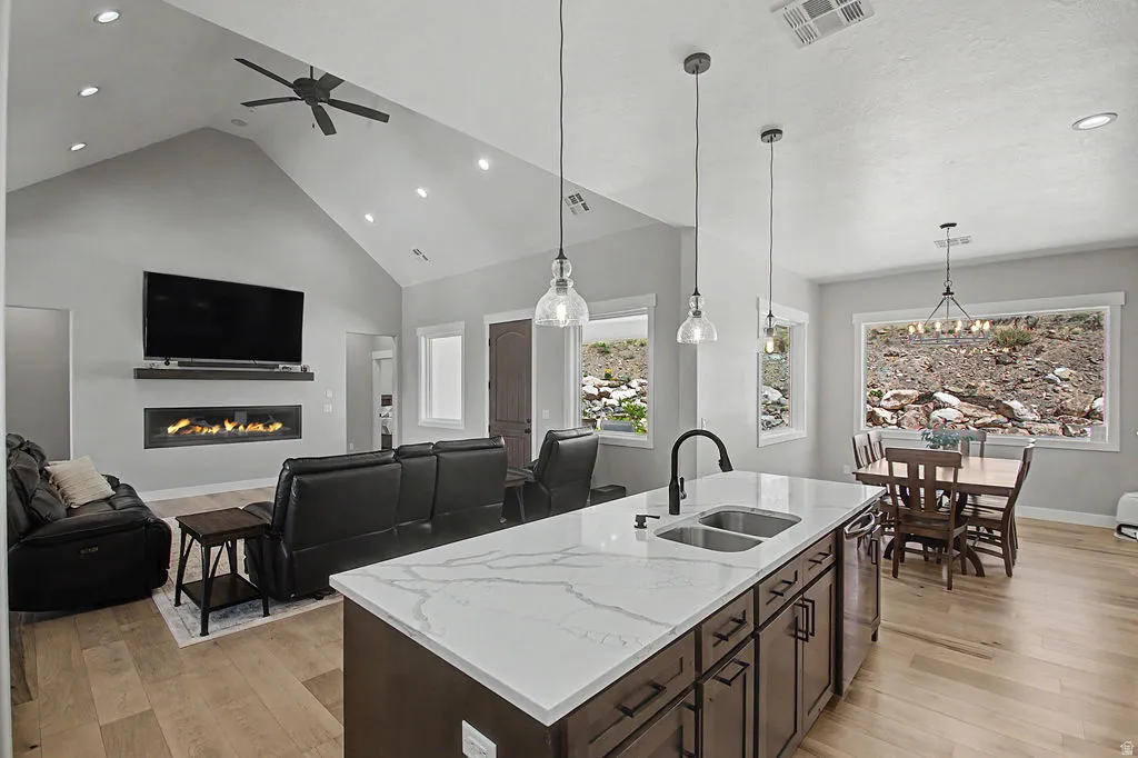 Spacious open-concept living area featuring a vaulted ceiling and wood-finish flooring