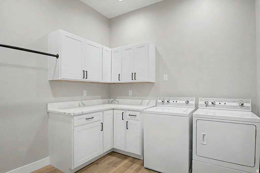 Dedicated laundry space featuring white cabinetry, light-toned countertops, and a built-in hanging rod