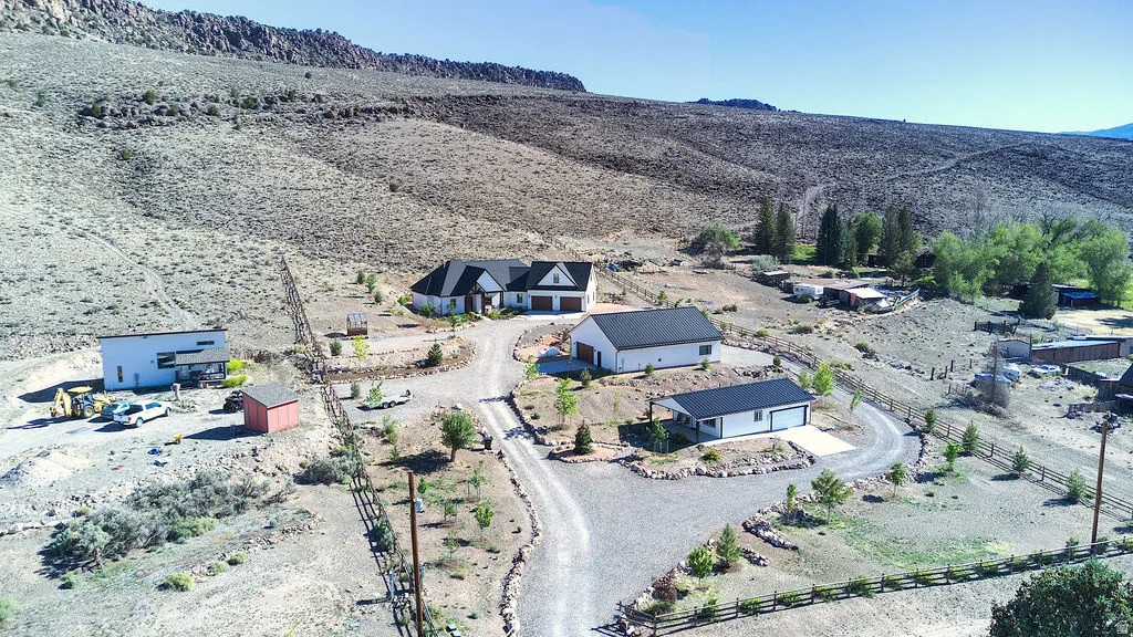 Sprawling property featuring multiple residences, a detached garage, and a long gravel driveway
