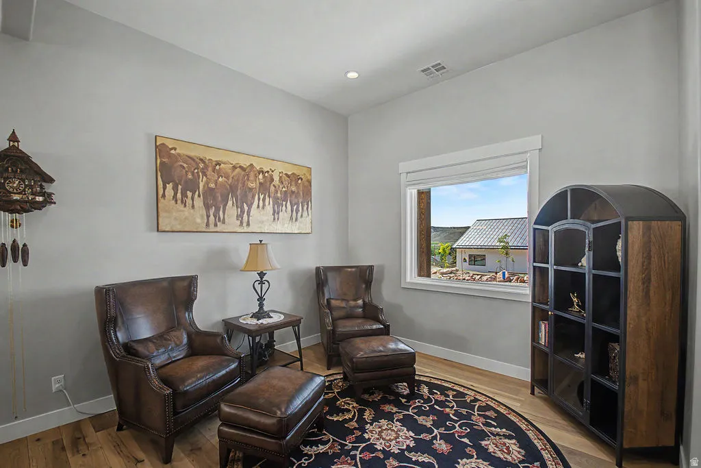 Light-toned walls complement wood-finish flooring in this room featuring a prominent window
