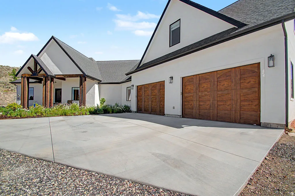 Contemporary residence featuring a white stucco exterior and dark gabled roofing