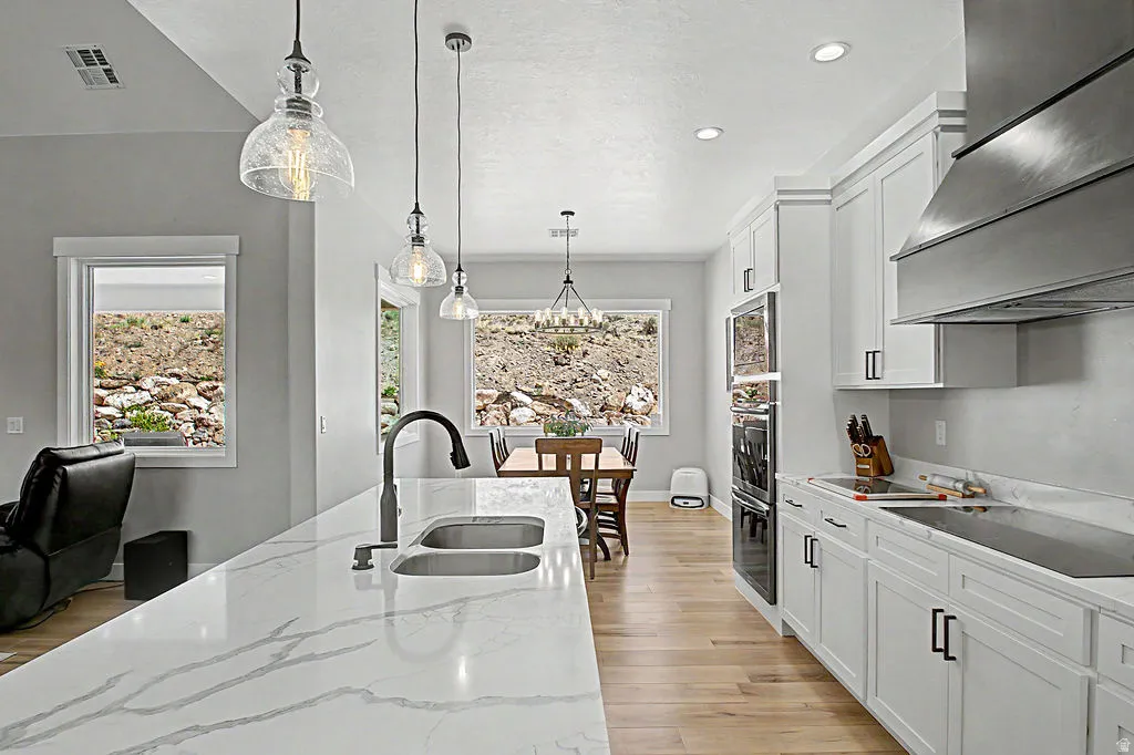 Open-concept kitchen featuring an expansive island with a dual-basin sink and modern faucet