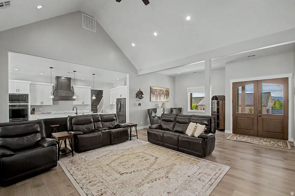 Vaulted living area featuring light wood-finish flooring, recessed lighting, and an open concept layout