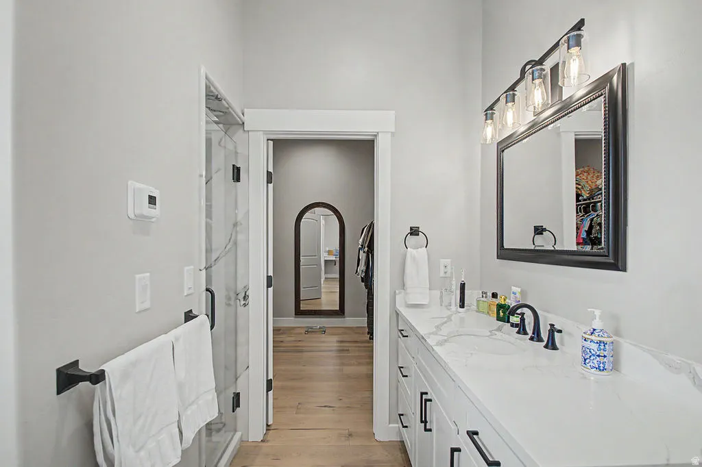Contemporary bathroom featuring a double vanity with white cabinetry, black hardware, and a light-toned countertop