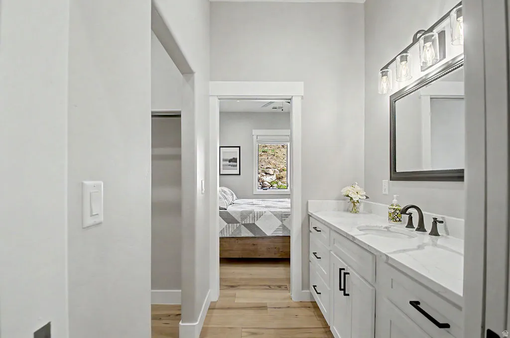 Dual vanity with white cabinetry and black hardware, quartz-finish countertop, single basin sink, and oil-rubbed bronze faucet